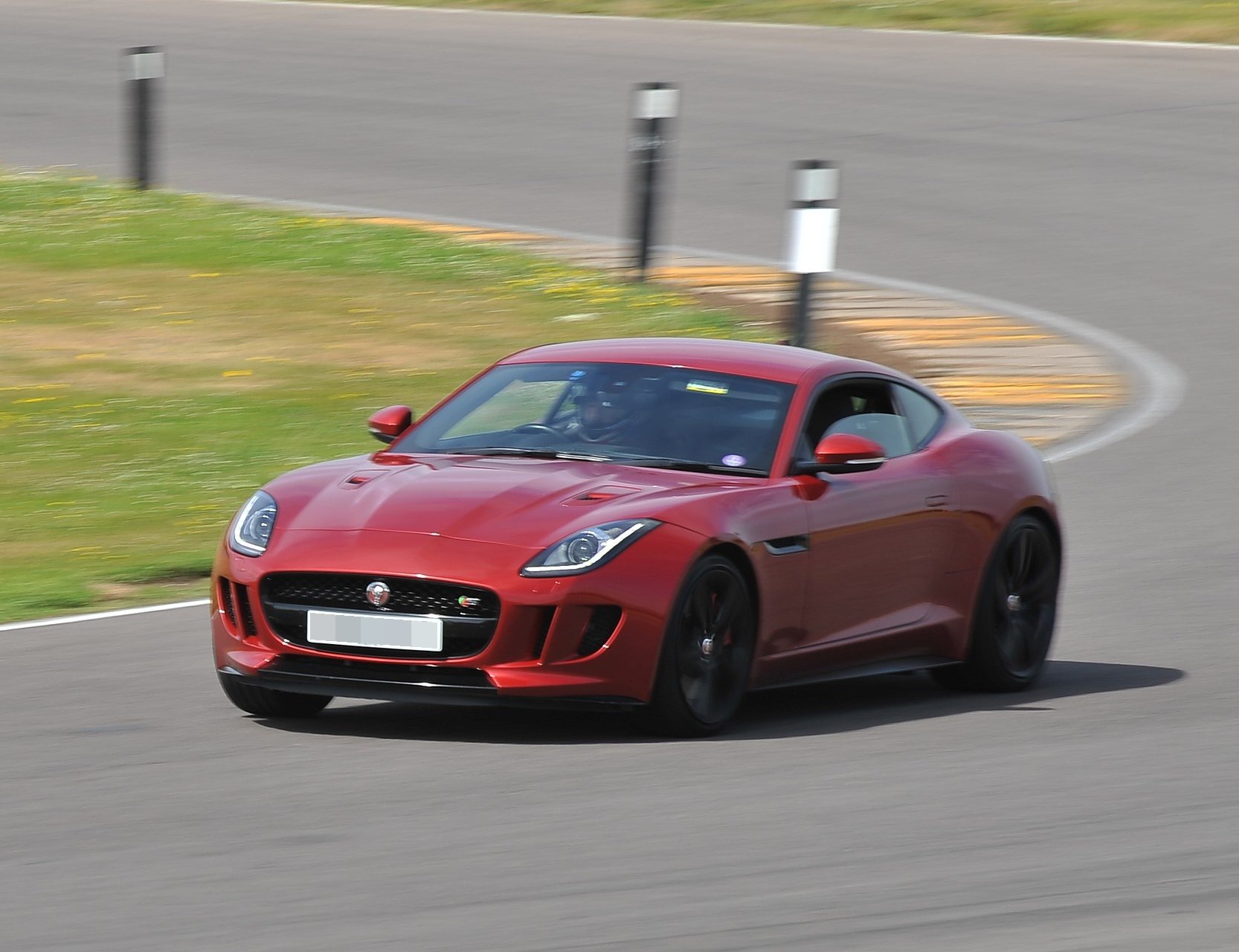 A red Jaguar F-Type coupé on track at a track day